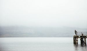 Preview wallpaper pier, man, loneliness, melancholia, lake, fog, water