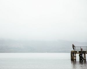 Preview wallpaper pier, man, loneliness, melancholia, lake, fog, water
