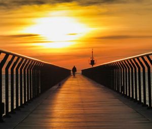 Preview wallpaper pier, man, silhouette, alone, sea, sunset