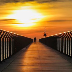 Preview wallpaper pier, man, silhouette, alone, sea, sunset