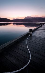 Preview wallpaper pier, mountains, lake, rope, sunset