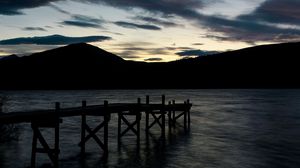 Preview wallpaper pier, mountains, silhouette, sunset