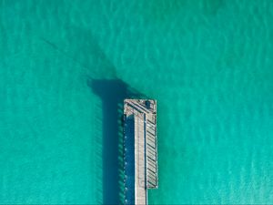 Preview wallpaper pier, ocean, shadow, top view, surface, turquoise