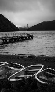 Preview wallpaper pier, river, mountains, boats, black and white