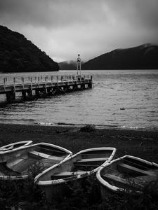 Preview wallpaper pier, river, mountains, boats, black and white