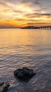 Preview wallpaper pier, stones, sea, sunset, horizon