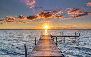 Preview wallpaper pier, sunset, rays, horizon, sea