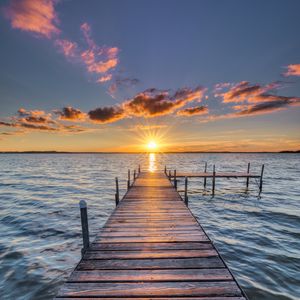 Preview wallpaper pier, sunset, rays, horizon, sea