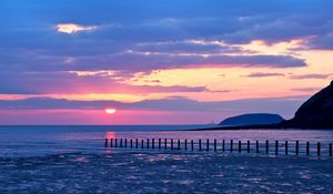 Preview wallpaper pilings, sea, sunset