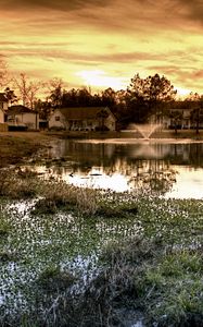 Preview wallpaper pond, fountain, houses, cloudy, evening