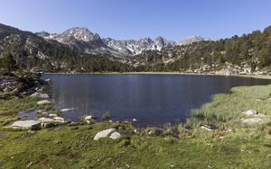 Preview wallpaper pond, mountains, grass, stones, landscape, nature