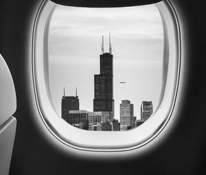 Preview wallpaper porthole, bw, airplane window, buildings, flight