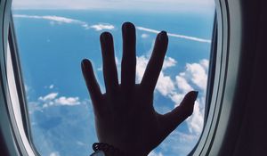 Preview wallpaper porthole, hand, airplane, window, clouds