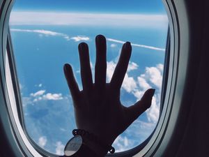 Preview wallpaper porthole, hand, airplane, window, clouds