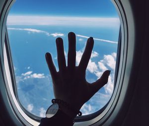 Preview wallpaper porthole, hand, airplane, window, clouds