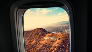 Preview wallpaper porthole, window, plane, flight, hollywood sign, los angeles, united states