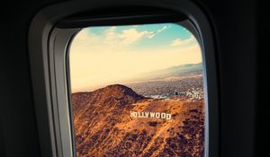 Preview wallpaper porthole, window, plane, flight, hollywood sign, los angeles, united states