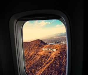 Preview wallpaper porthole, window, plane, flight, hollywood sign, los angeles, united states