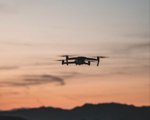 Preview wallpaper quadcopter, drone, flight, mountains, silhouette, sunset