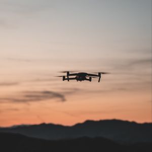 Preview wallpaper quadcopter, drone, flight, mountains, silhouette, sunset