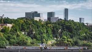 Preview wallpaper railroad, train, buildings, trees, city