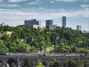 Preview wallpaper railroad, train, buildings, trees, city