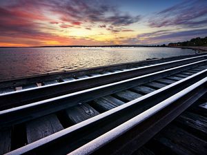 Preview wallpaper rails, cross ties, railway, sea, evening, clouds