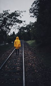 Preview wallpaper raincoat, man, railway, lonely, autumn, yellow