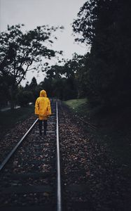 Preview wallpaper raincoat, man, railway, lonely, autumn, yellow