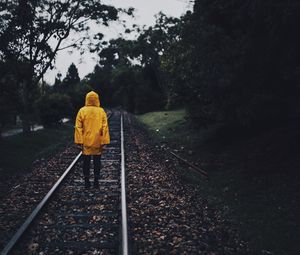 Preview wallpaper raincoat, man, railway, lonely, autumn, yellow