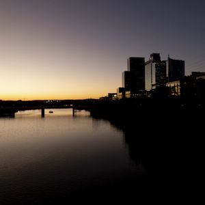 Preview wallpaper river, city, buildings, bridge, dark, shadows