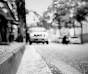 Preview wallpaper road, asphalt, petals, blur, bw