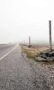 Preview wallpaper road, asphalt, strip, fog, stones, columns, indexes