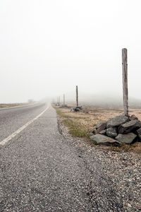 Preview wallpaper road, asphalt, strip, fog, stones, columns, indexes