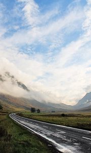 Preview wallpaper road, asphalt, wet, mountains, haze, sky, clouds, way, uncertainty, valley