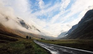Preview wallpaper road, asphalt, wet, mountains, haze, sky, clouds, way, uncertainty, valley