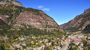 Preview wallpaper road, buildings, mountains, trees, sky