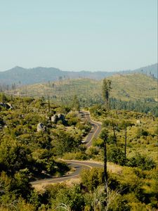 Preview wallpaper road, bushes, stones, hills, distance