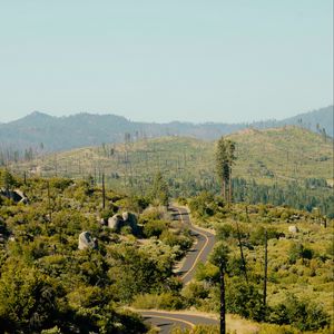 Preview wallpaper road, bushes, stones, hills, distance