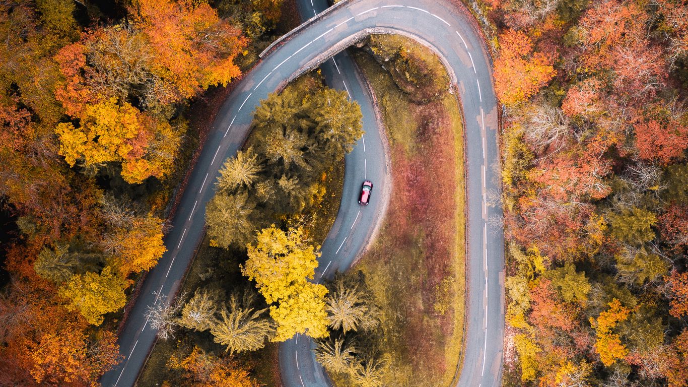 Download wallpaper 1366x768 road, car, aerial view, trees, autumn