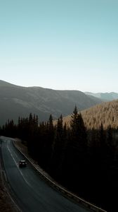 Preview wallpaper road, car, mountains, forest, movement