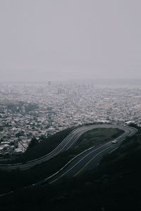 Preview wallpaper road, city, aerial view, fog, buildings, car