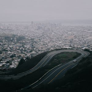 Preview wallpaper road, city, aerial view, fog, buildings, car