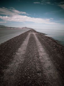 Preview wallpaper road, coast, stones, water, hills, clouds