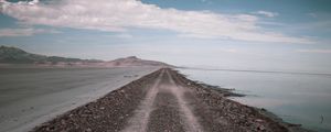 Preview wallpaper road, coast, stones, water, hills, clouds