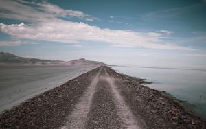 Preview wallpaper road, coast, stones, water, hills, clouds