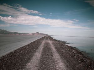 Preview wallpaper road, coast, stones, water, hills, clouds