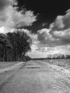 Preview wallpaper road, country, black-and-white, trees, clouds, volume