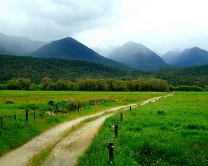 Preview wallpaper road, country, field, protections, stakes, wire, green, summer, mountains, fog