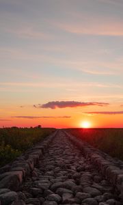 Preview wallpaper road, distance, sunset, stones, grass
